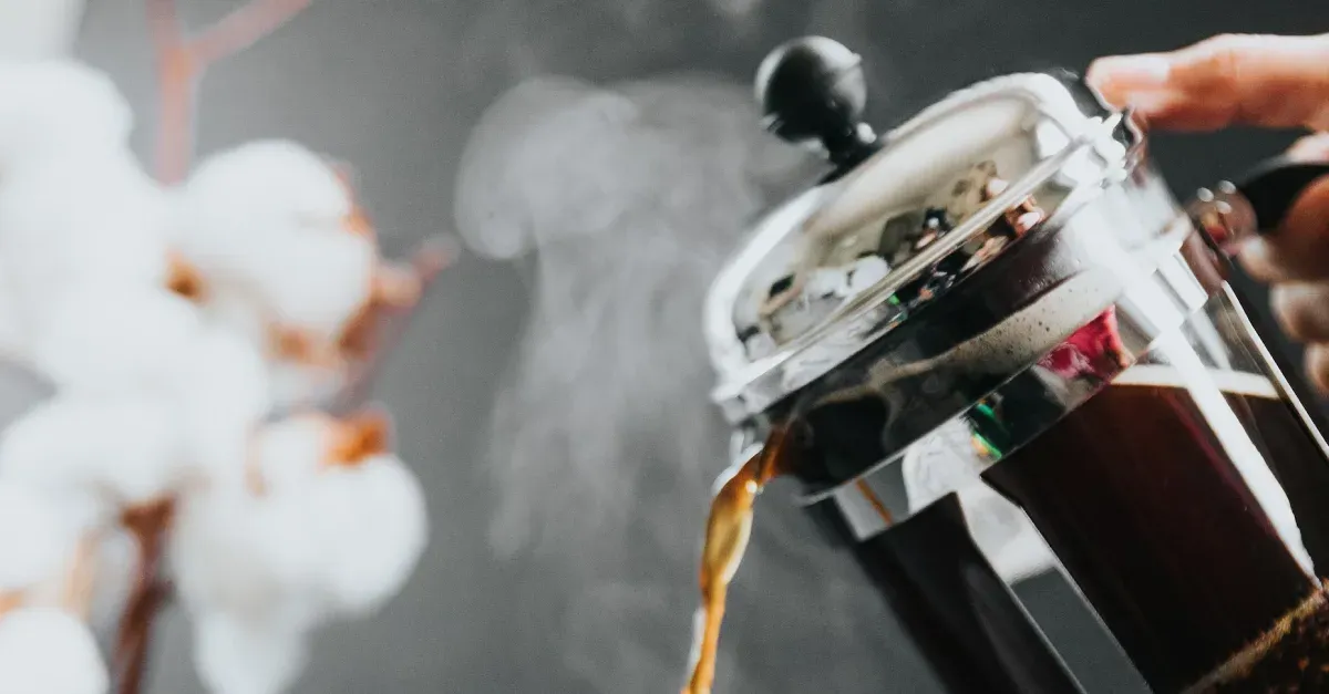 A person pouring coffee from a french press