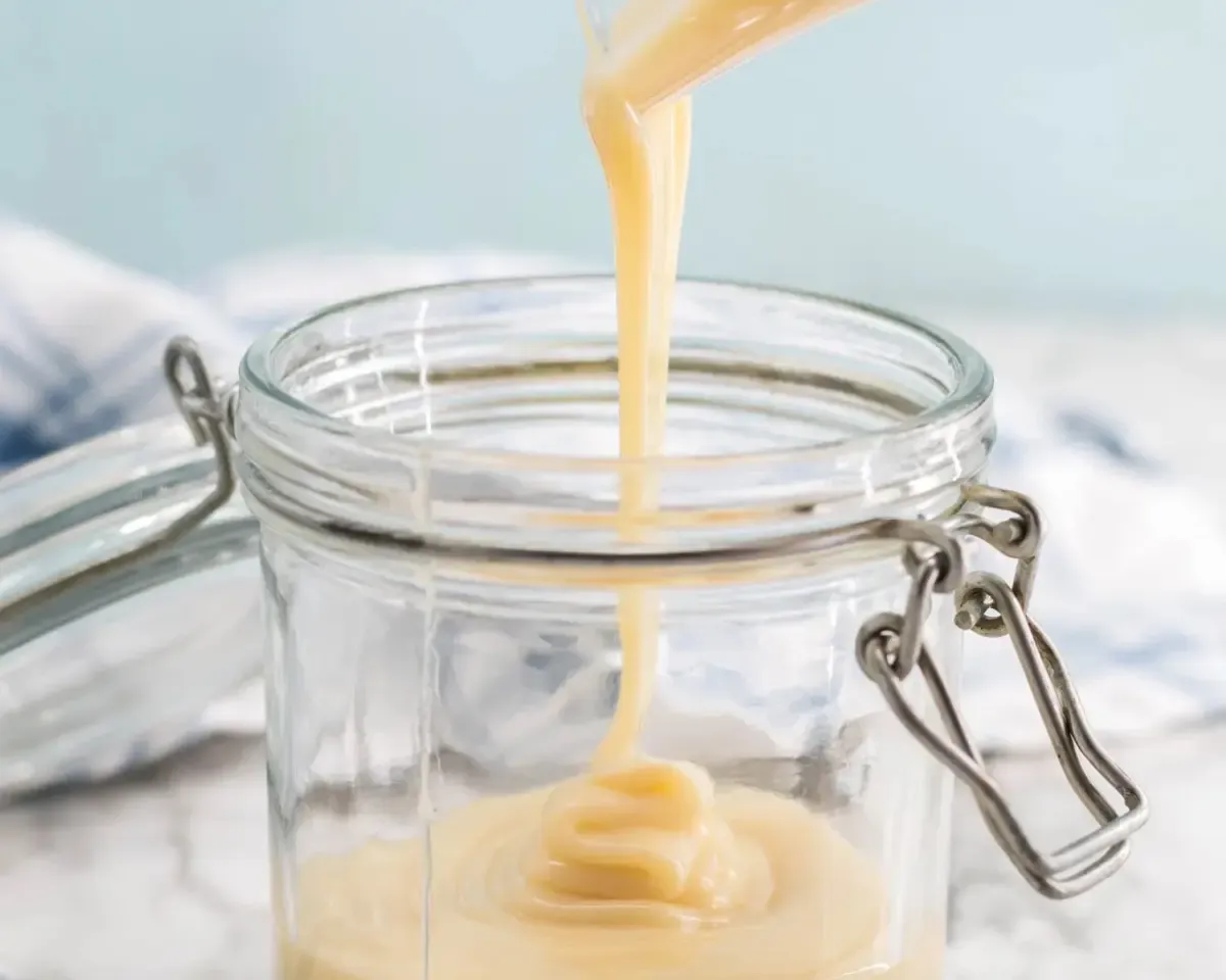 Condensed milk being poured in a jar