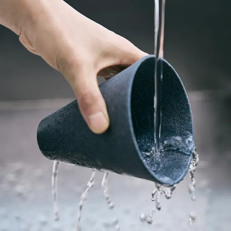 A hand washing a cerapotta filter under water