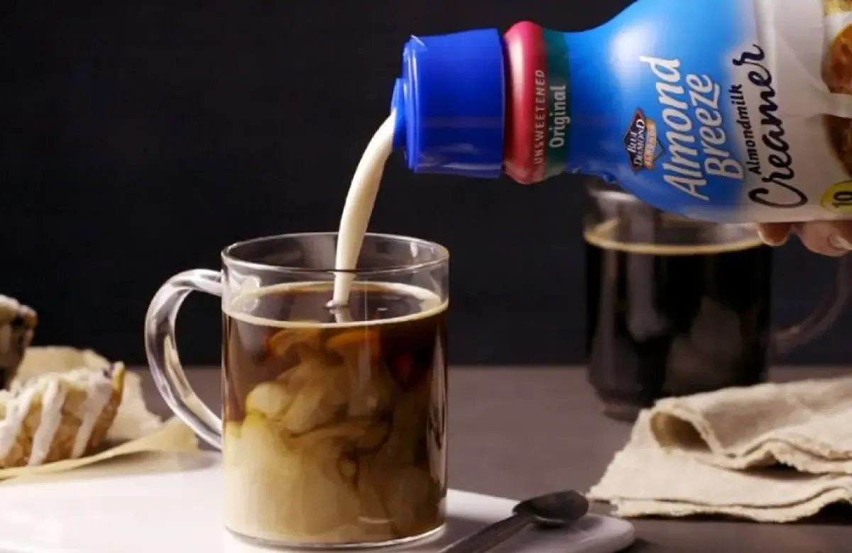 Pouring sugar free creamer into coffee
