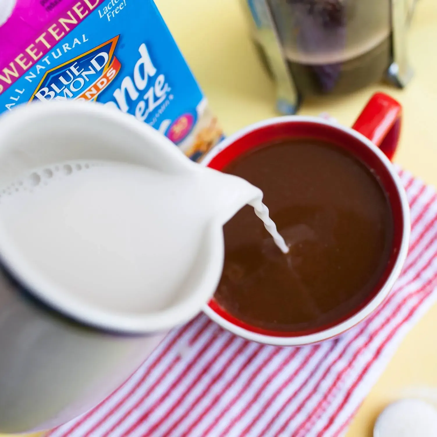 Pouring almond milk into coffee