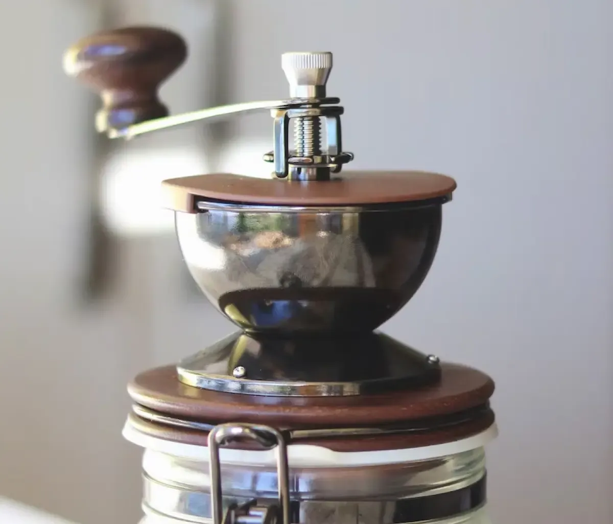 Manual coffee grinder on top of a jar