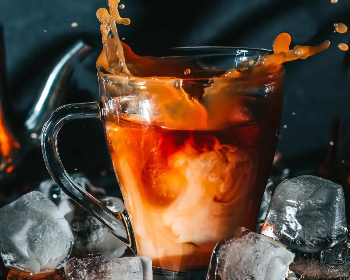 Ice cubes falling into a cup of coffee