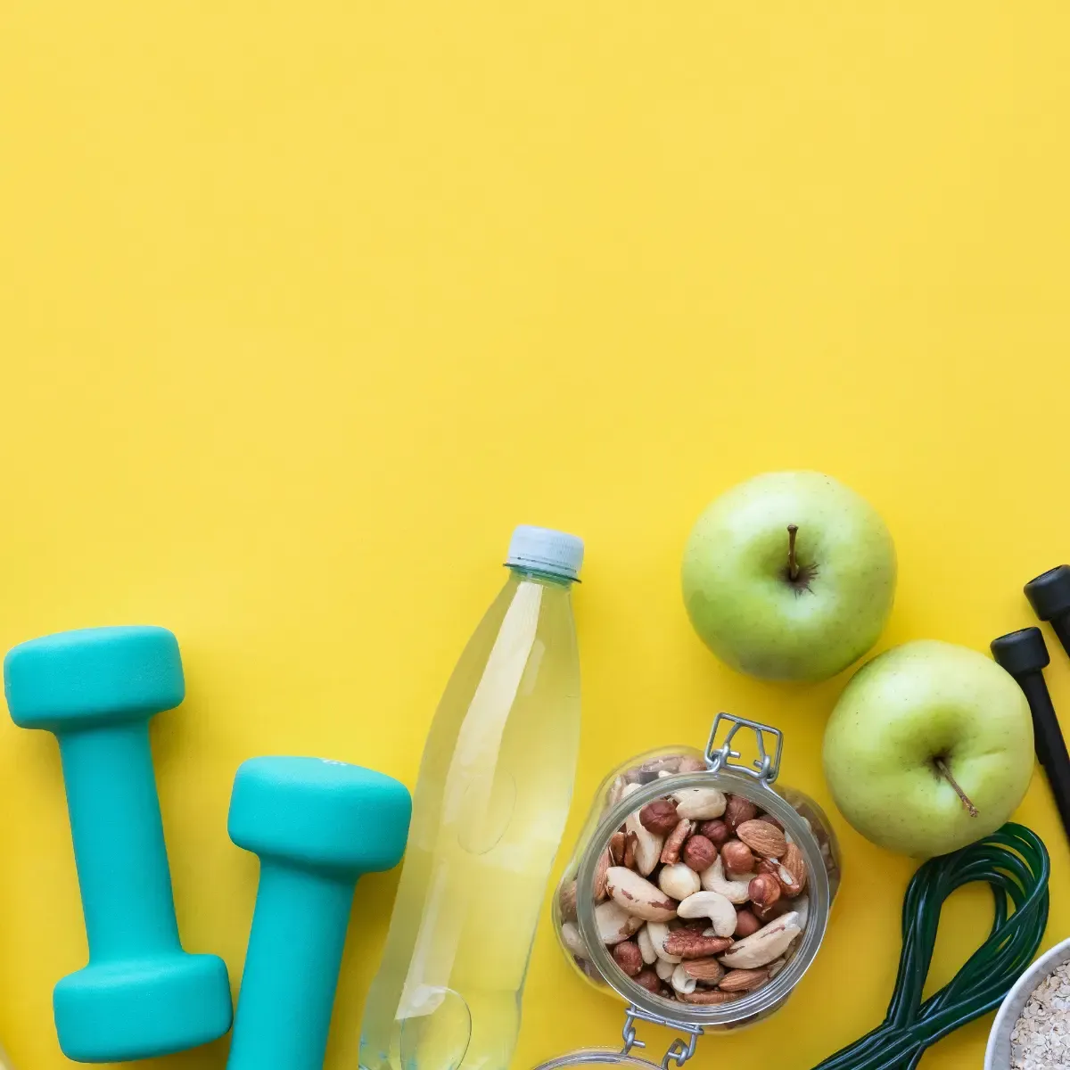 yellow background with green apples, weights, nuts and objects refering to health