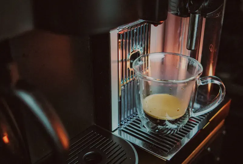 A coffee cup sitting under a Nespresso machine