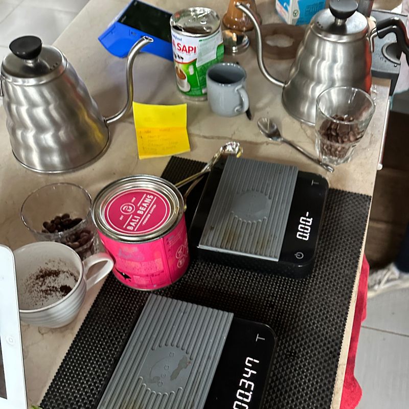 coffee scales, coffee, kettles, cups and coffee beans on a kitchen counter