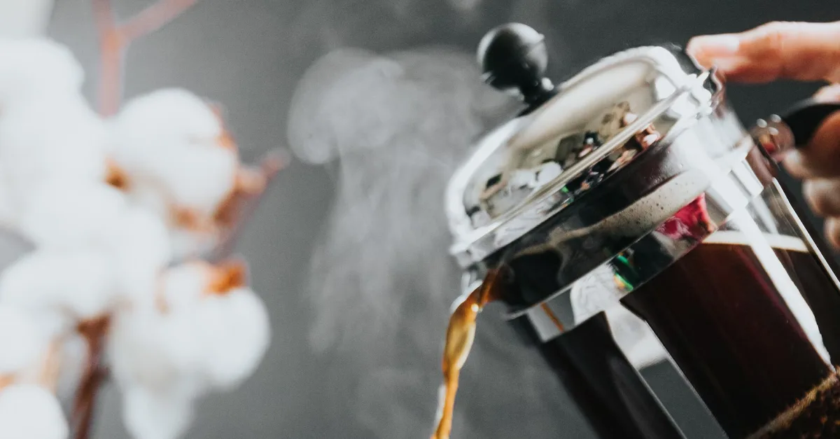 A person pouring coffee from a french press
