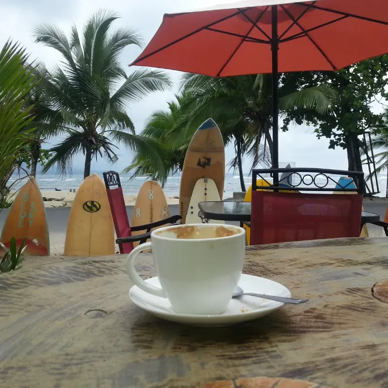 An empty coffee cup on a table by a beach