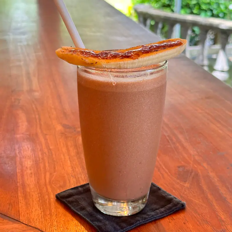 Smoothie of banana, dates, chocolate powder in a tall glass