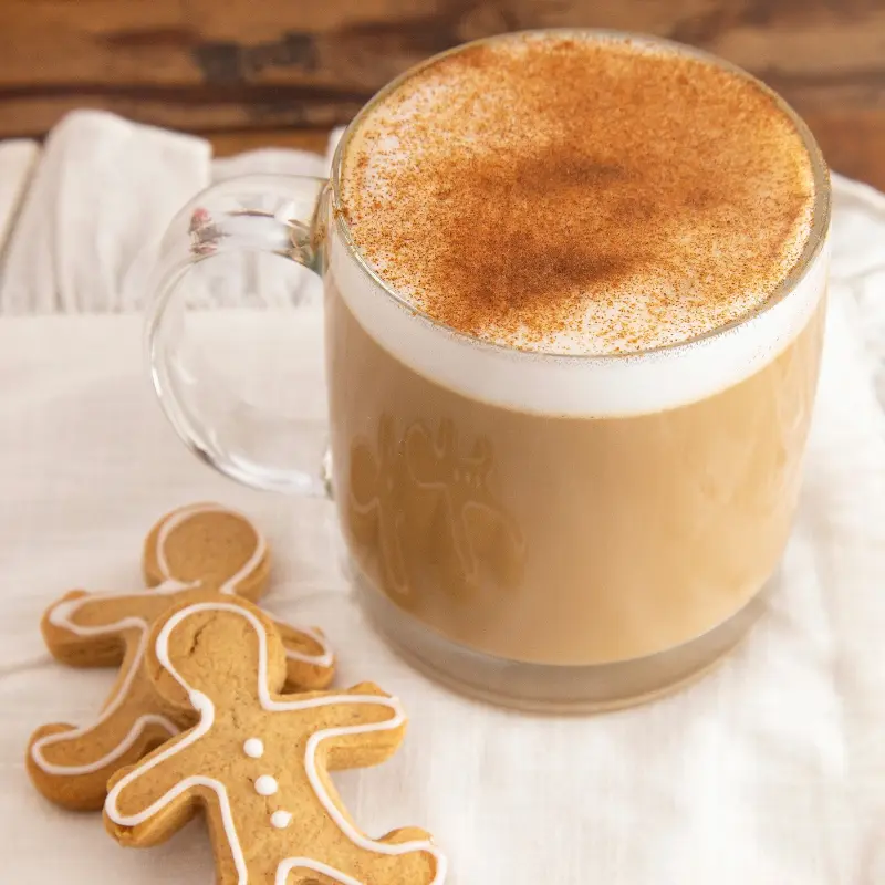 Gingerbread latte in a glass cup with gingerbread cookie