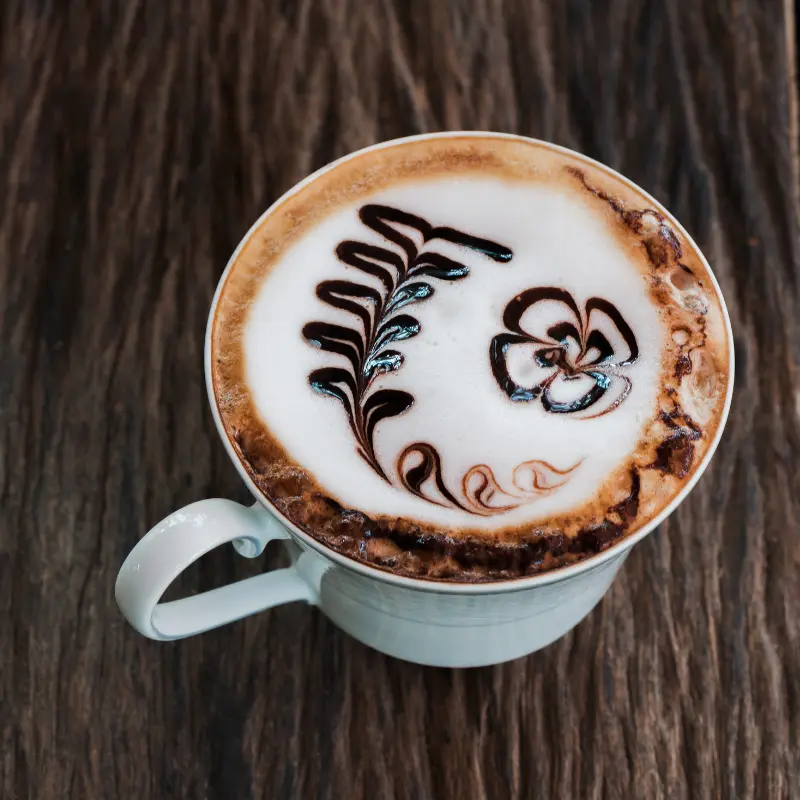 Mocha coffee in a cup with chocolate swirls on top